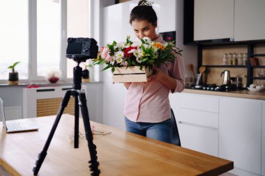 Blog 'unda eve çevrimiçi ders vermek için kamera kullanan bir kadın