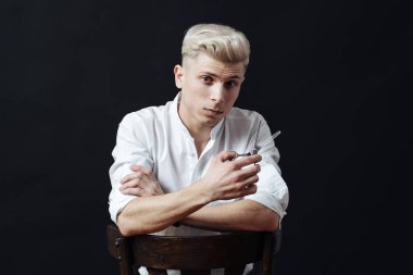 Kuaför aksesuarlarıyla ayakta duran erkek stilistin portresi.