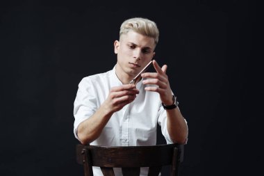 Kuaför aksesuarlarıyla ayakta duran erkek stilistin portresi.