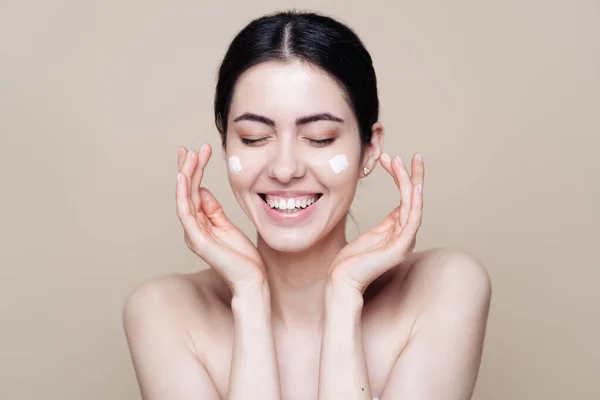 Beautiful Caucasian woman applying cream on face — Stock Photo, Image