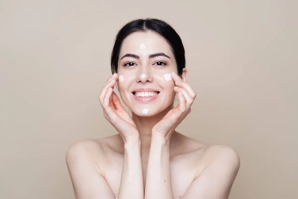 Beautiful Caucasian woman applying cream on face — Stock Photo, Image