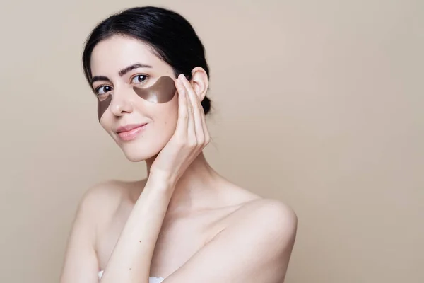 Mulher bonita nova com pele facial fresca limpa, usa manchas oculares — Fotografia de Stock