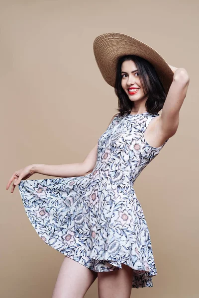 Красивая брюнетка на отдыхе в летней шляпе и платье — стоковое фото