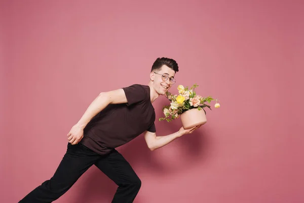 Boldog jóképű fiatalember kezében egy csokor virággal.. — Stock Fotó