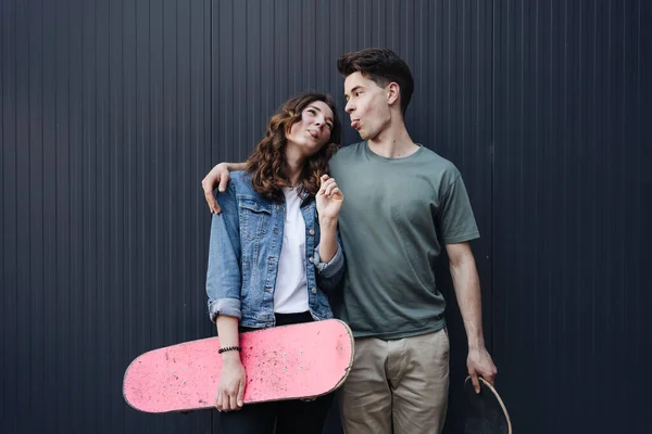 Modernes lächelndes Paar im Stehen mit Skateboards — Stockfoto