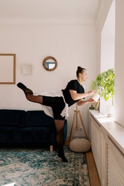 Çiçekleri sularken bale yapan güzel bir bayan.