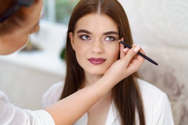 Makyaj sanatçısı, güzellik salonu stüdyosunda çalışıyor.