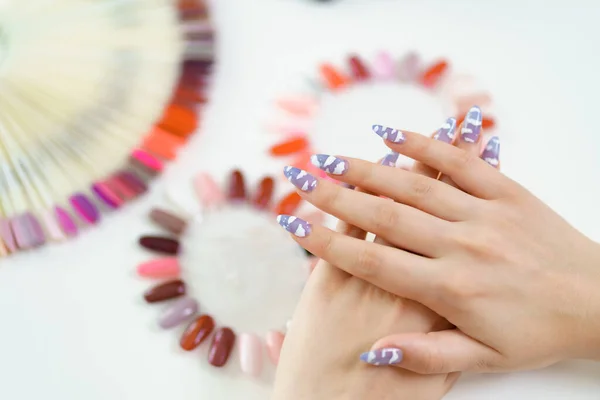 Bella manicure su sfondo tavolozza dei colori — Foto Stock