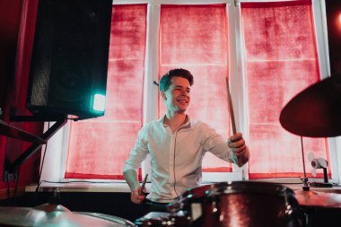 Yakışıklı adam konsere hazırlanırken davul çalıyor.