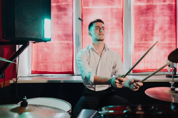 Yakışıklı adam konsere hazırlanırken davul çalıyor.