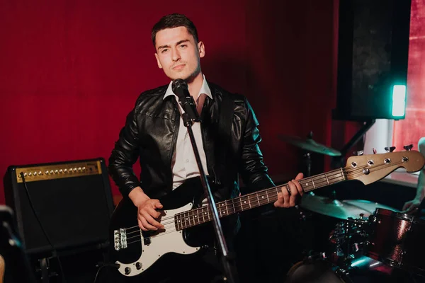 Fiatal férfi hipster felvétel új hangok stúdióban, miközben játszik elektro gitár és ének — Stock Fotó
