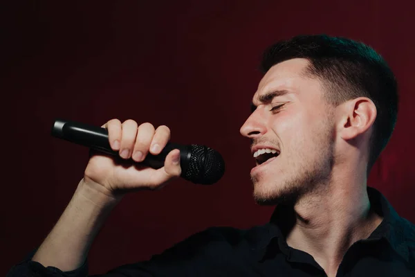 Man in leather jacket performing on a dark stage in club — Stock Photo, Image