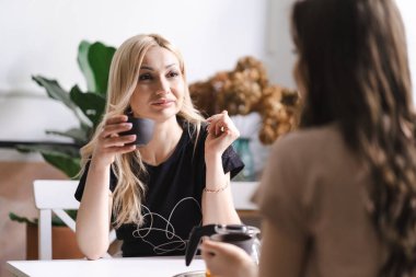 Anne ve kızı mutfaktaki masada çay içiyorlar.