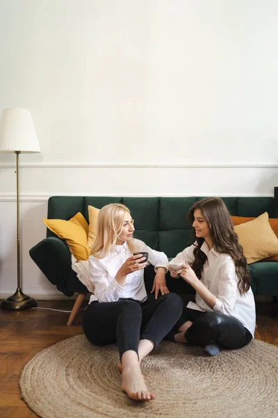 Mãe com filha bebendo chá juntos na sala de estar em casa — Fotografia de Stock