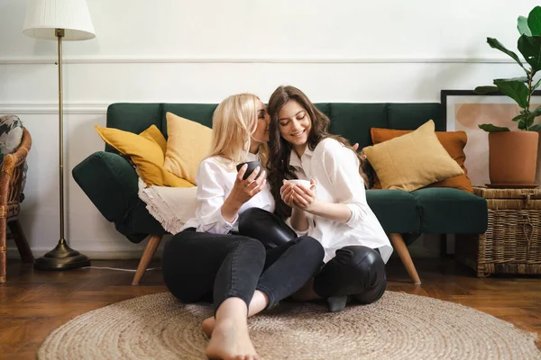 Mãe com filha bebendo chá juntos na sala de estar em casa — Fotografia de Stock