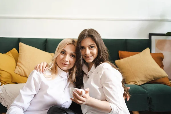 Mère avec sa fille buvant du thé ensemble dans le salon à la maison — Photo