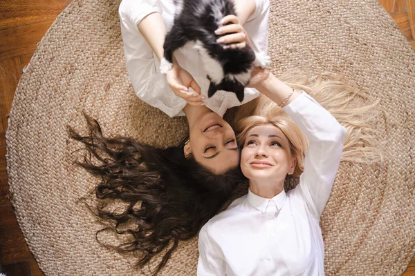 Mãe e filha deitada no chão enquanto brincava com o gato — Fotografia de Stock