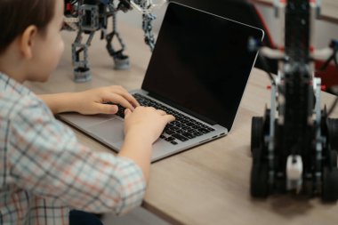 Çocuk tam fonksiyonel robot yapıyor ve bunu okul robotları için dizüstü bilgisayarla programlıyor.
