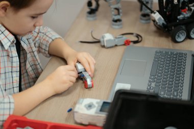 Çocuk tam fonksiyonel robot yapıyor ve bunu okul robotları için dizüstü bilgisayarla programlıyor.