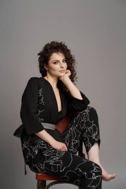 Gri arkaplanda kıvırcık kadın portresi