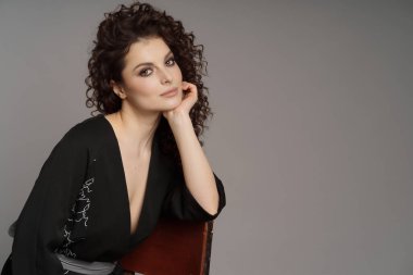 Gri arkaplanda kıvırcık kadın portresi