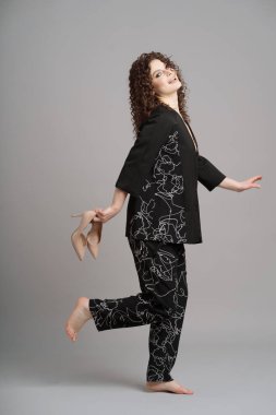 Ellerinde çıplak ayakkabılar olan güzel kıvırcık kadın.