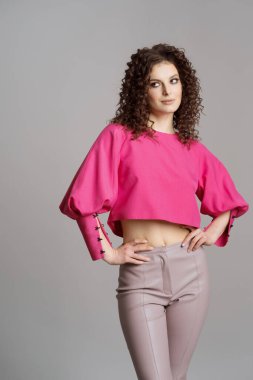 Stüdyo gri arka planda renkli elbiseli bir kadın.