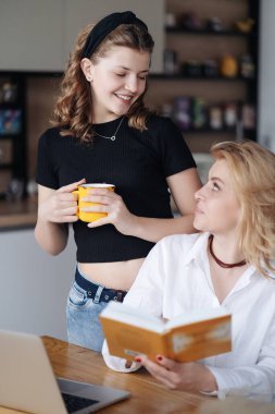 Anne ve kızı bir kitabı tartışıyor.