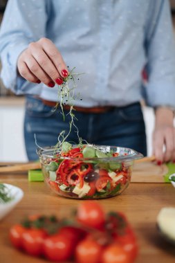 Kadın elleri salata pişiriyor.