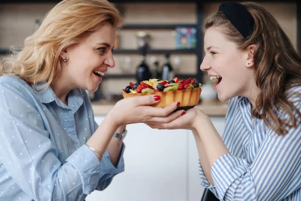Anya és lánya otthon esznek finom bogyós sütit. — Stock Fotó