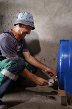 Şarap üreticisi kırmızı şarabı tadıyor.