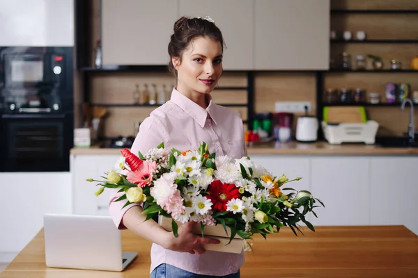 Retrato mujer sonriente con una hermosa composición de flores — Foto de Stock