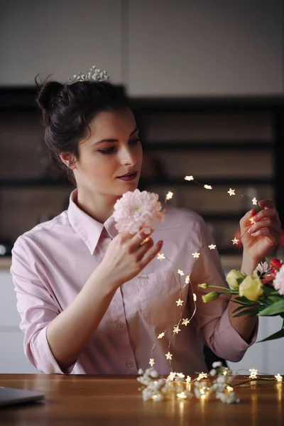 Florista mujer piensa cómo decorar flores con luces led — Foto de Stock