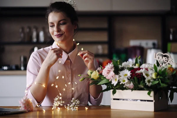 Florista mujer piensa cómo decorar flores con luces led — Foto de Stock