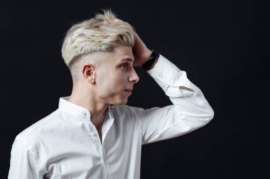 Gülümseyen adam siyah arka planda yakın plan portresi.