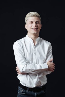 Gülümseyen adam, koyu gri arka plana yakın portre.