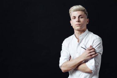 Kuaför aksesuarlarıyla ayakta duran erkek stilistin portresi.