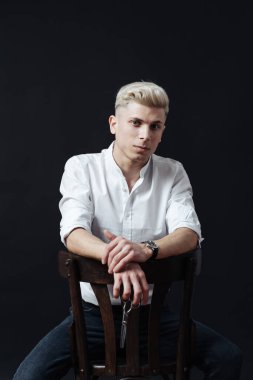 Kuaför aksesuarlarıyla ayakta duran erkek stilistin portresi.