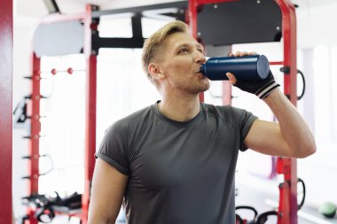 Spor yaparken su içen adam.