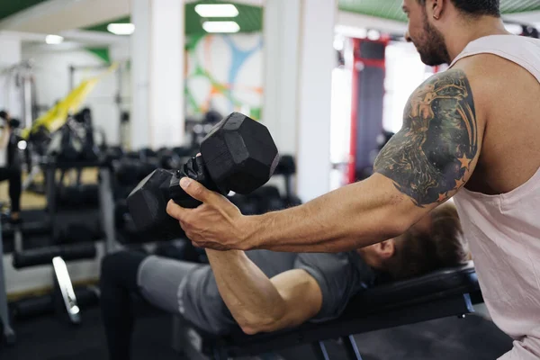 Jovem tem treino com personal trainer no ginásio — Fotografia de Stock