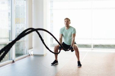 Genç sporcu, geniş bir alanda iple antrenman yapıyor.