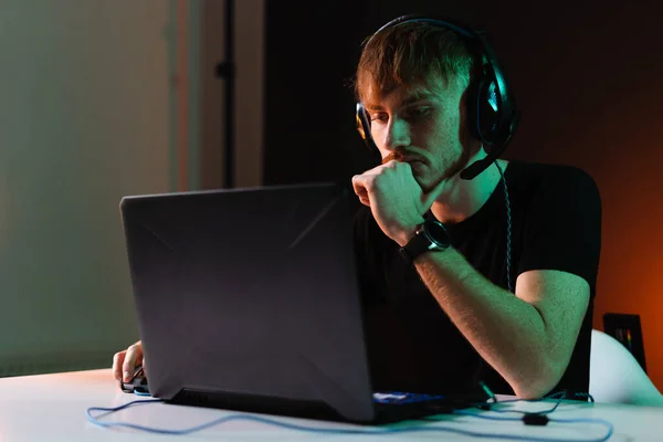Gamer jogar jogos de vídeo com fones de ouvido no fundo de luz de néon — Fotografia de Stock