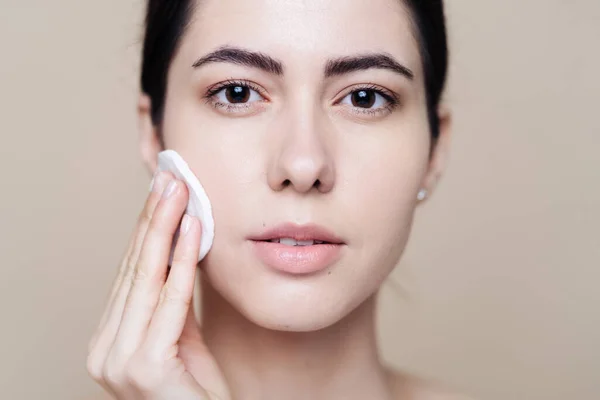 Young brunette woman removing makeup from her face — Stock Photo, Image