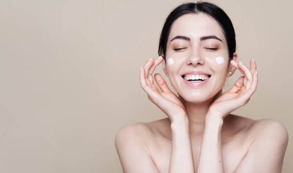 Beautiful Caucasian woman applying cream on face — Stock Photo, Image