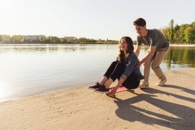 Genç çift dışarıda kaykay çalışıyor.