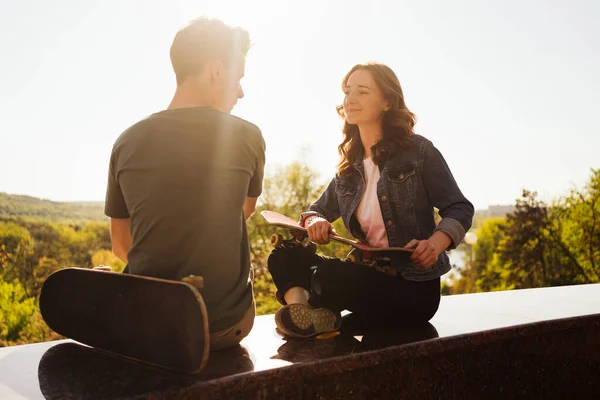 Moderní usmívající se pár stojící spolu s skateboardy — Stock fotografie