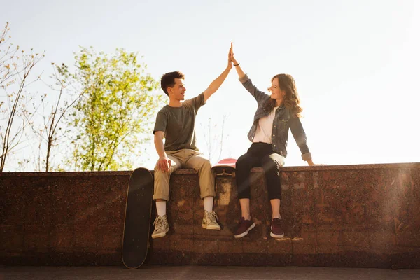 Modernt leende par som står tillsammans med skateboards — Stockfoto