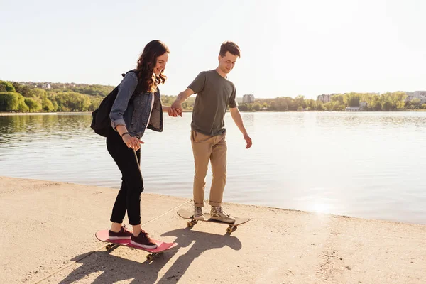 Mladý pár trénink skateboarding venku — Stock fotografie