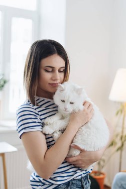 Evinde sevimli kedisi olan güzel genç bir kadın.