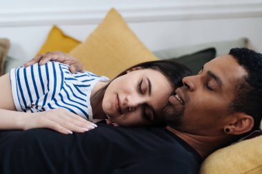 Genç çift evdeki kanepede dinleniyor.